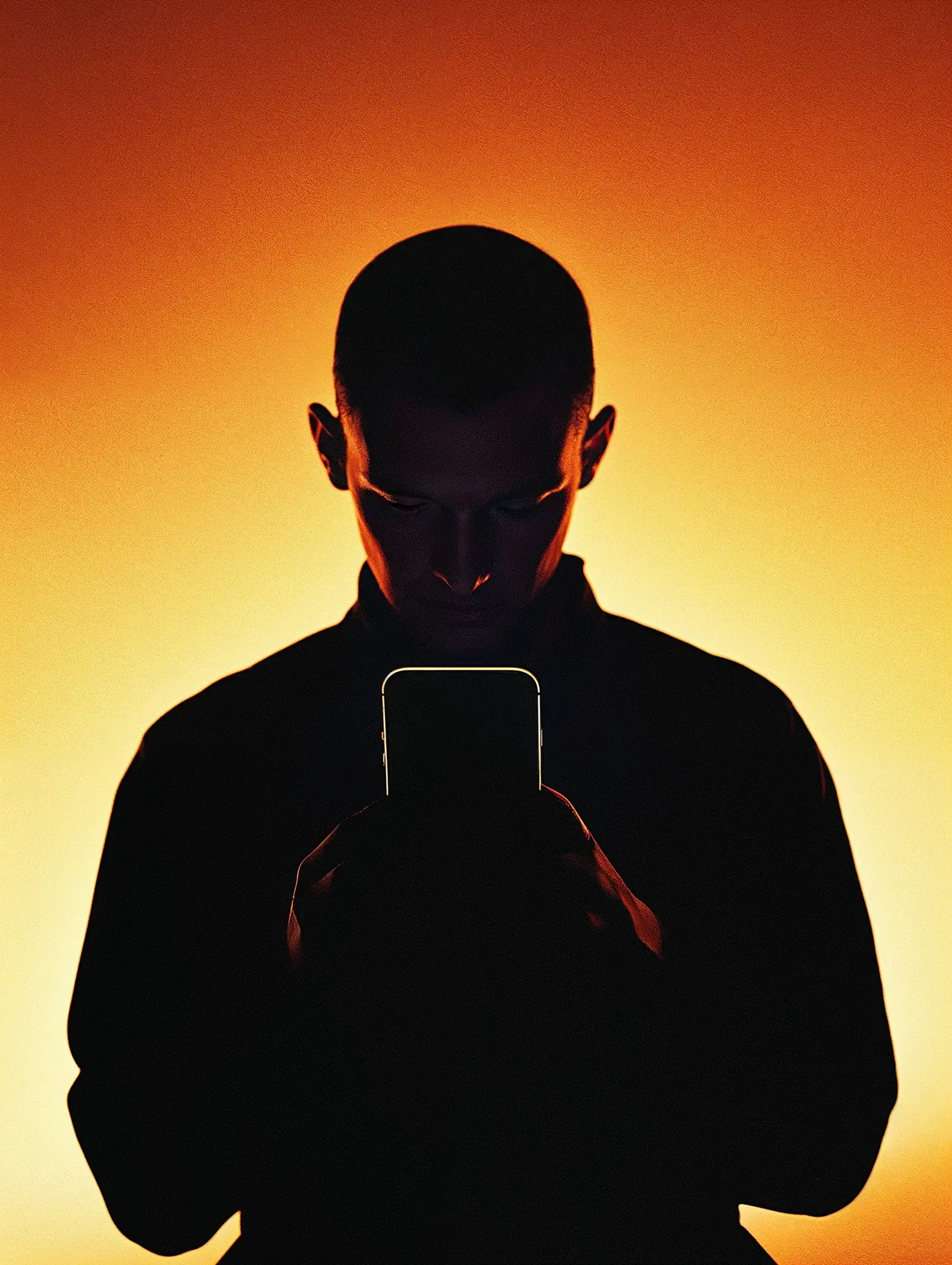 Evermynd_Sample_Images7 Silhouette einer Person mit Smartphone vor leuchtend orangefarbenem Hintergrund – Symbol für datengetriebenes Marketing, digitale Innovation und technologiegestützte Markenstrategie.